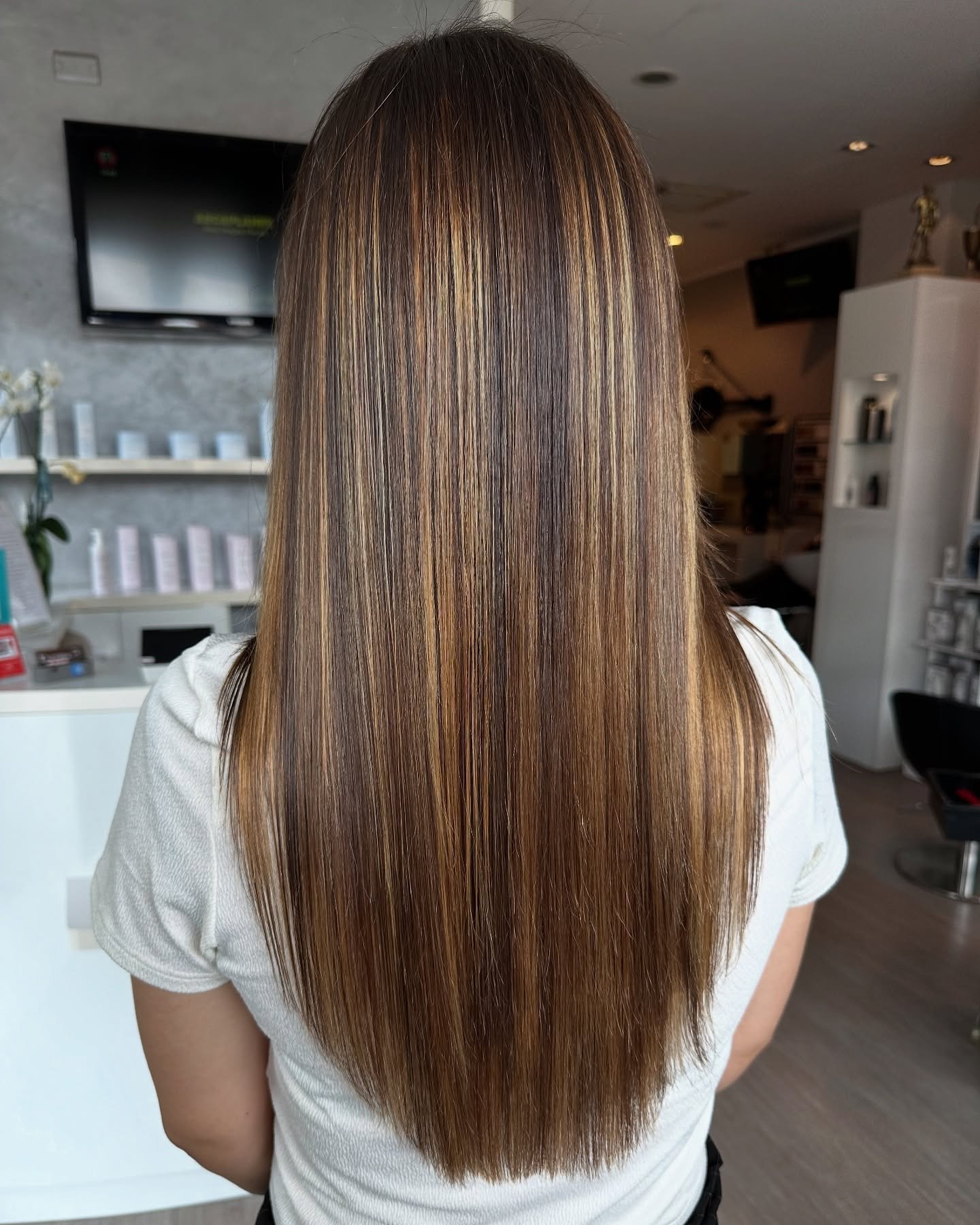 Sleek, straight hair showing a seamless root-to-end color melt.